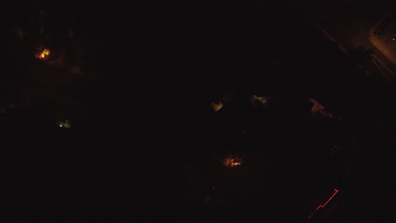 Top-down night view in Hidden Lake, Colorado, showing dim orange lights, a small pale light, and shadowed ground with no visible people.