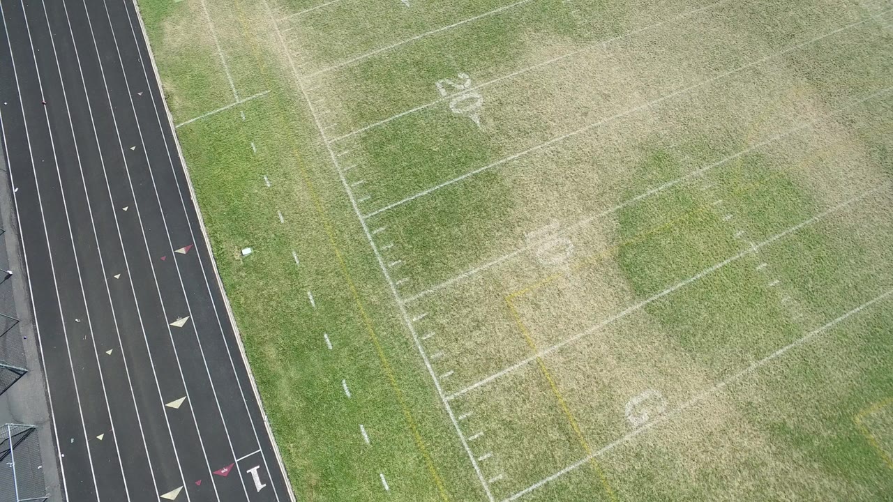 Overhead view of a football field beside a running track.