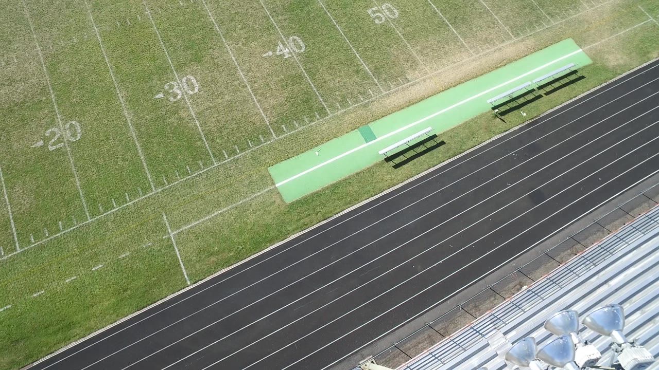 Aerial frame in Hidden Lake, Colorado with the 30, 40, and 50 yard markings visible above a black track, bleachers at the lower edge, and no visible people.