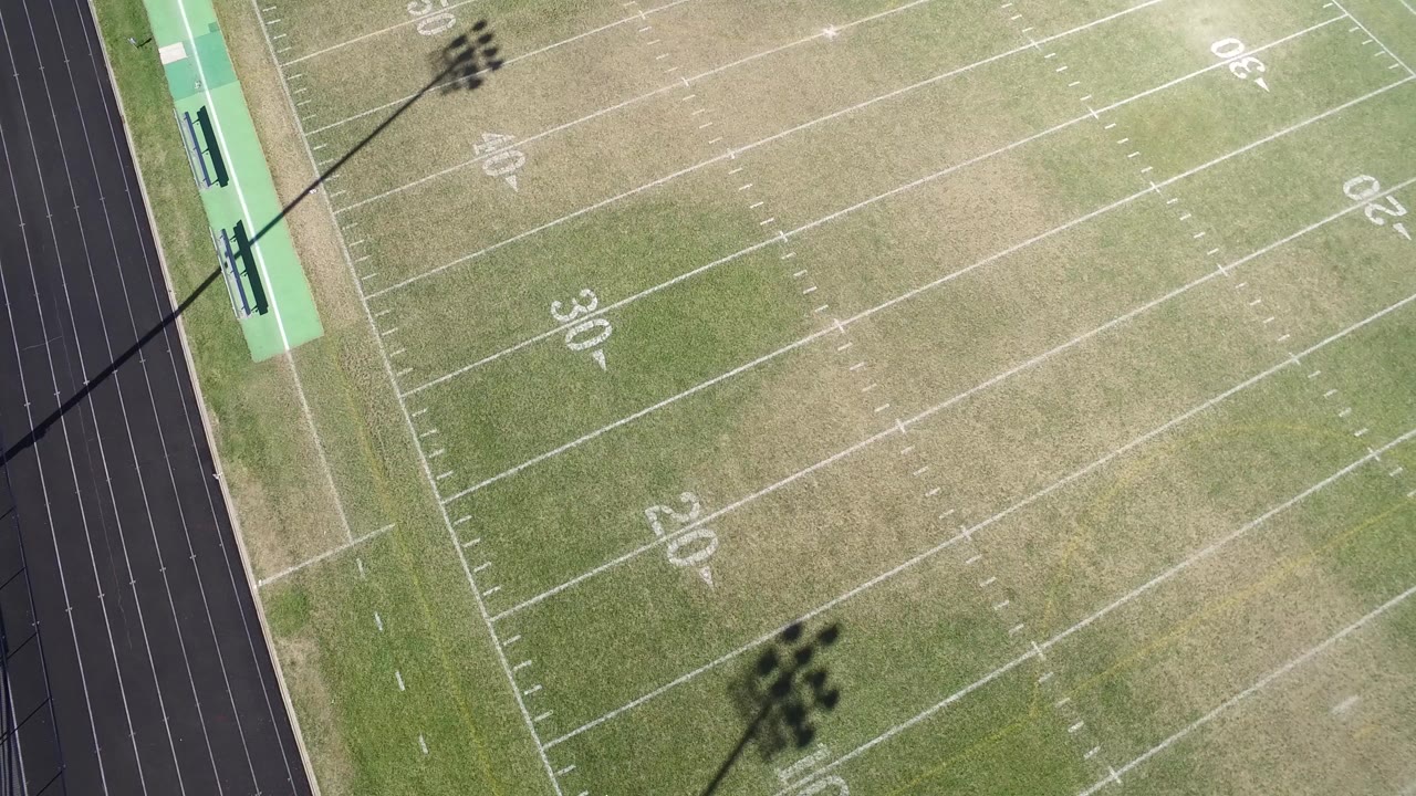 Overhead view of a football field beside a running track.