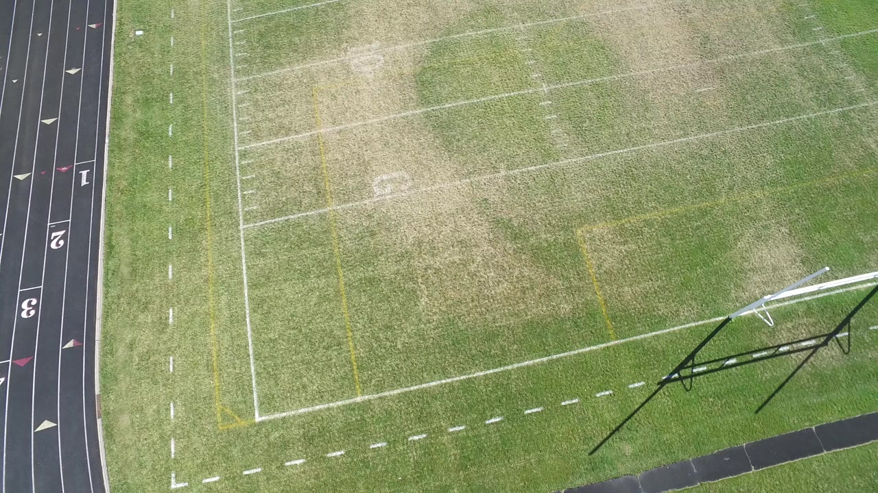 Overhead view of a football field beside a running track.