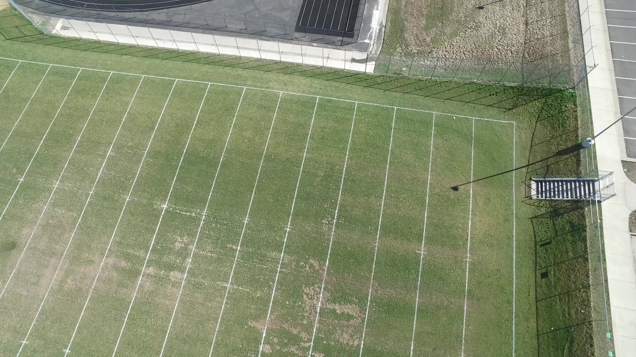 Top-down frame of the Hidden Lake football field with white yard lines, uneven grass color, a sideline walkway, and no visible people.