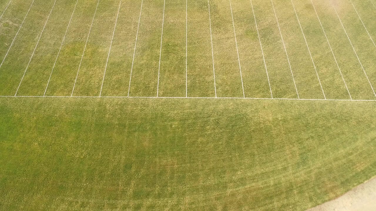 Overhead view of a green marked field in Hidden Lake, Colorado, with pale diagonal lines across the upper half and no visible people.