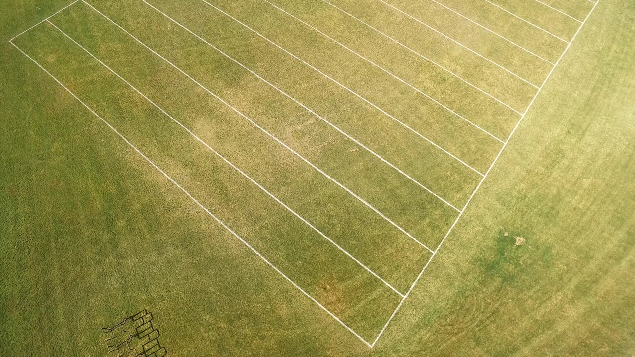 Overhead view of a grassy marked field in Hidden Lake, Colorado, with white rectangular lines crossing the upper frame and no visible people.