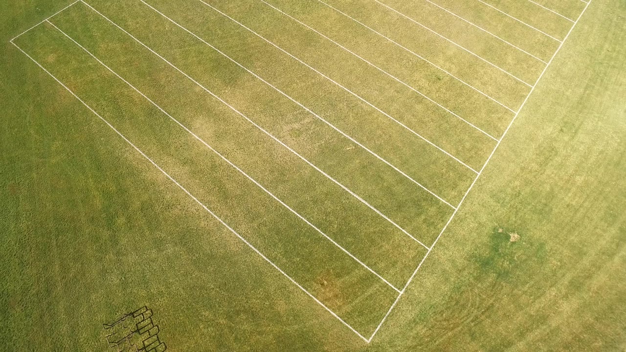 Aerial frame over Hidden Lake, Colorado grassland with angled white parallel and rectangular markings, mottled turf, and no visible people.