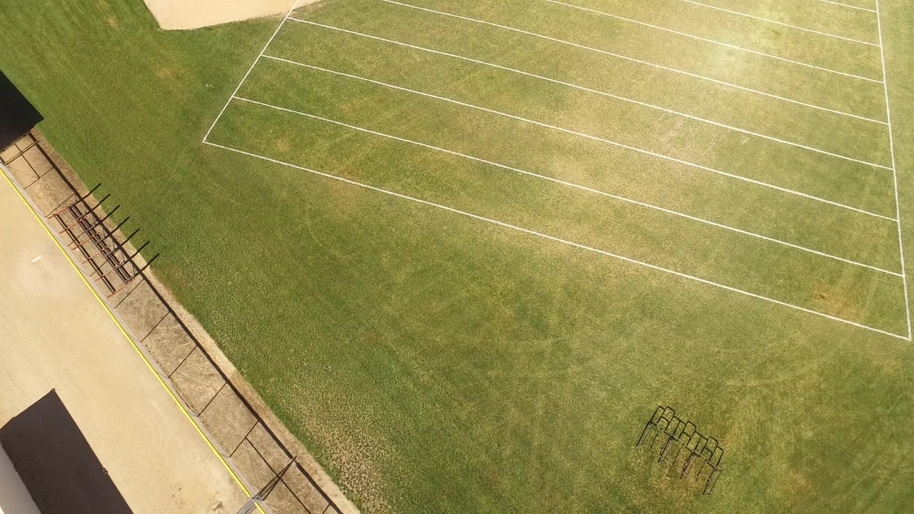 Overhead grass area with white court lines and tan pathway