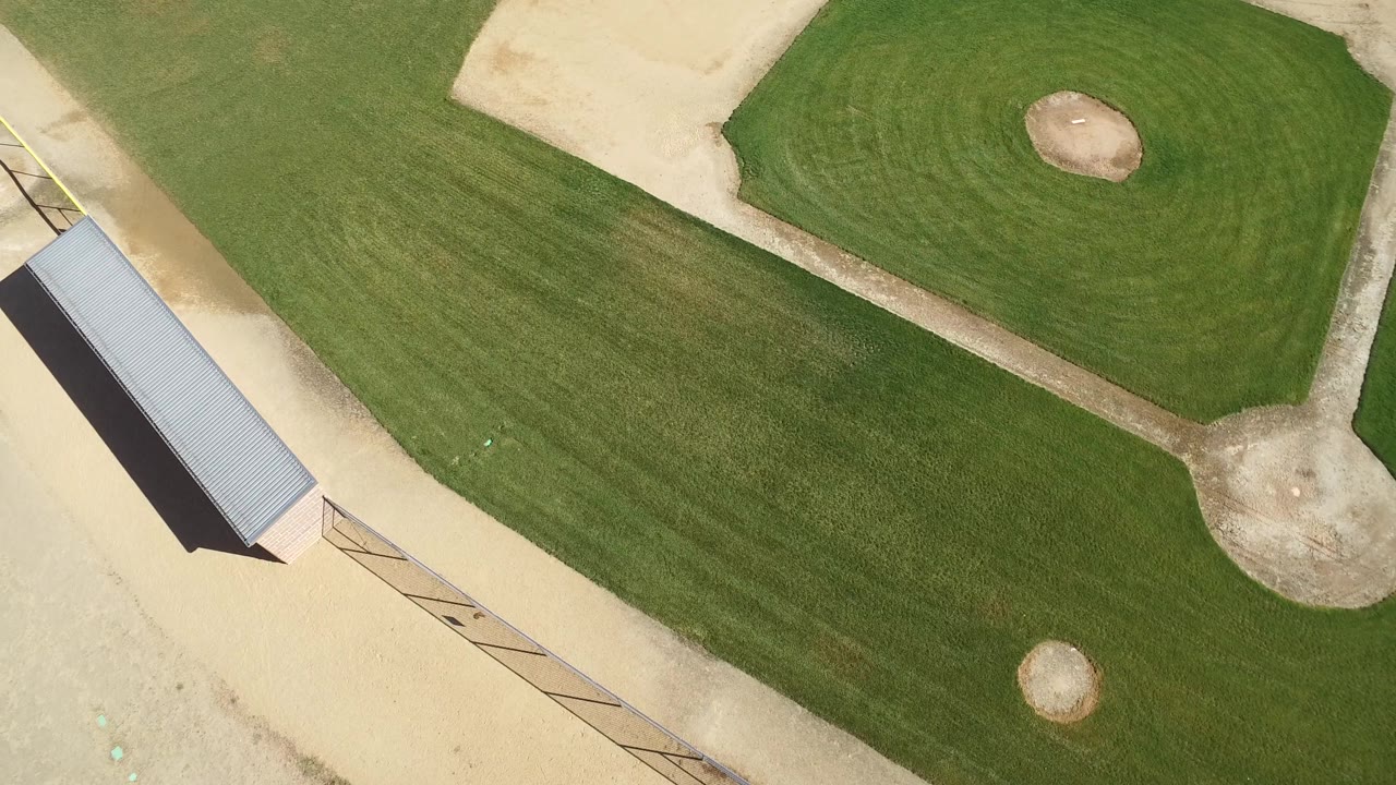 Aerial view of grass diamond, dirt infield, and shelter roof