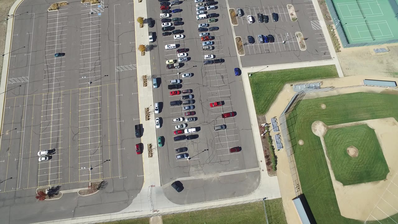 Overhead parking lot beside baseball field and tennis courts