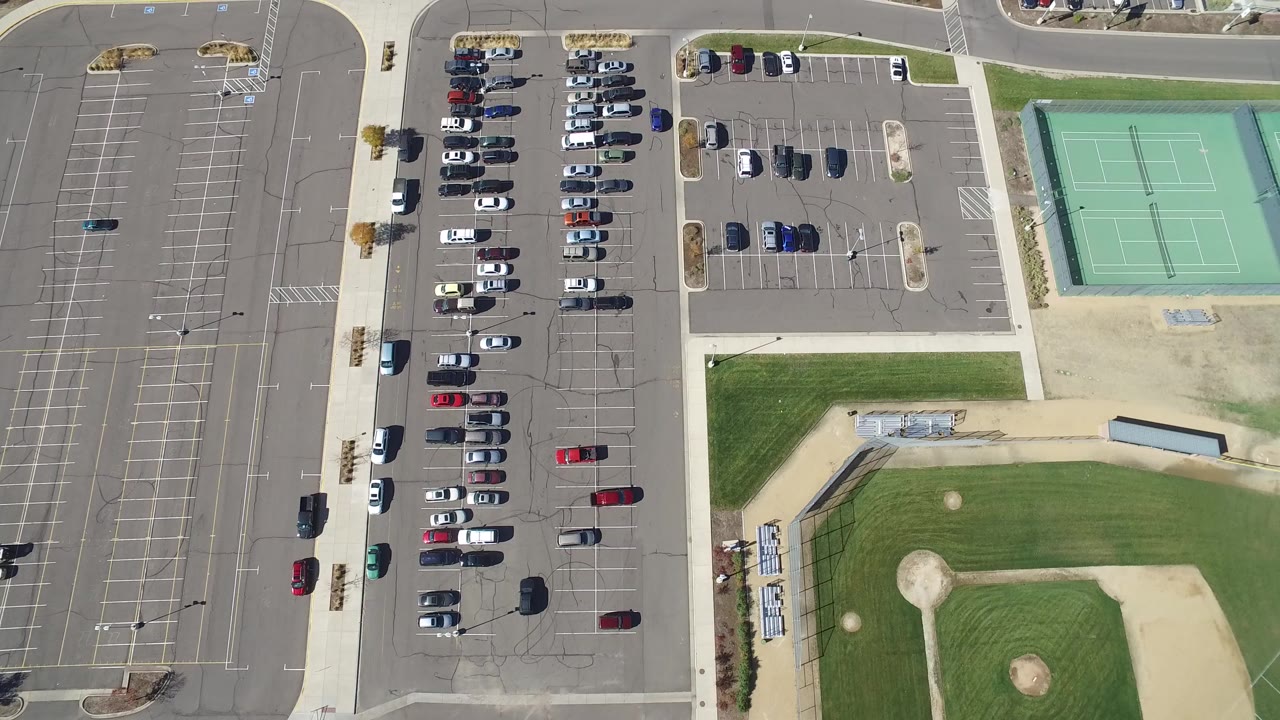 Overhead parking lots beside tennis courts and a baseball field.