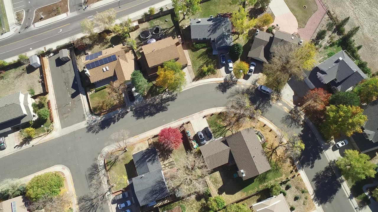 Top-down aerial view of houses along curved residential streets.