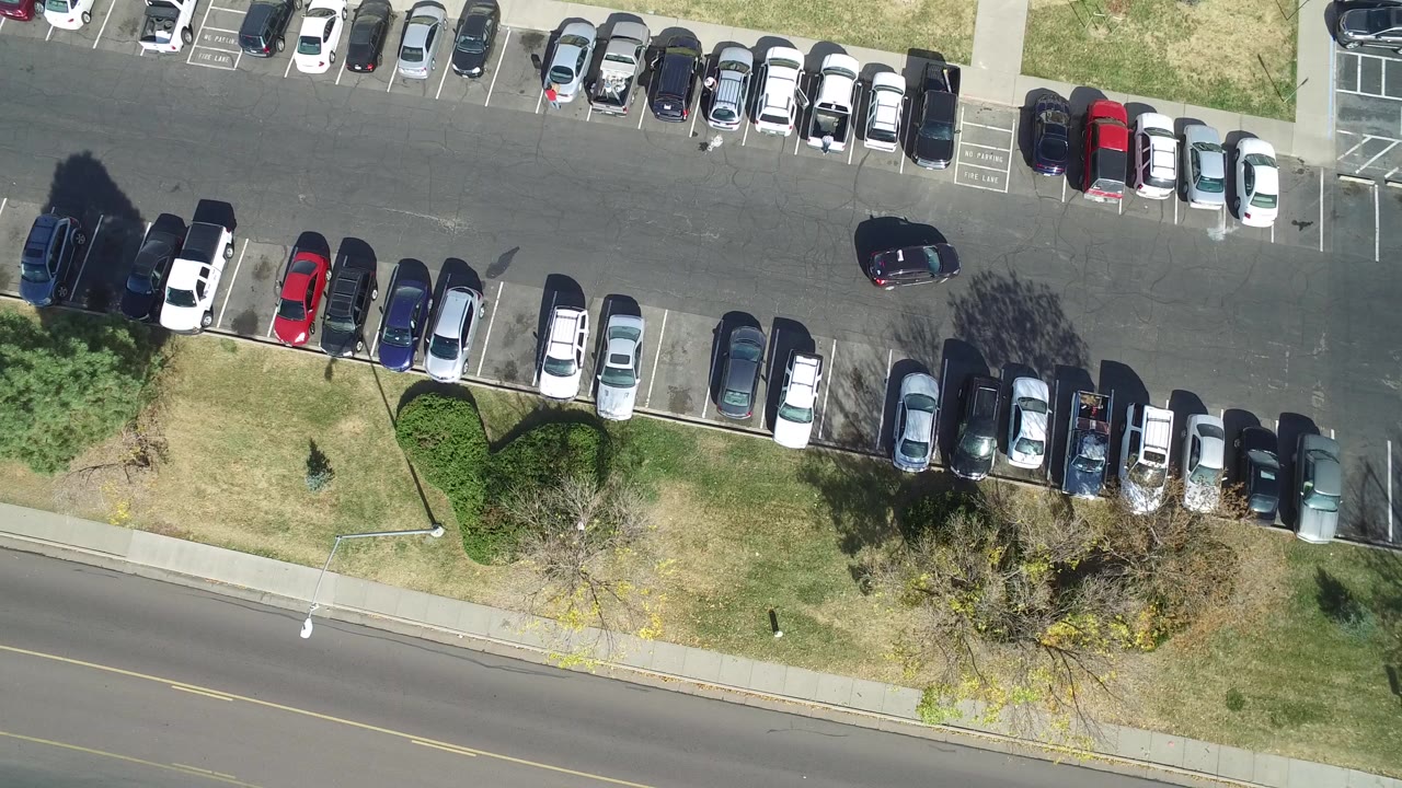 Overhead parking lot and road with rows of parked cars