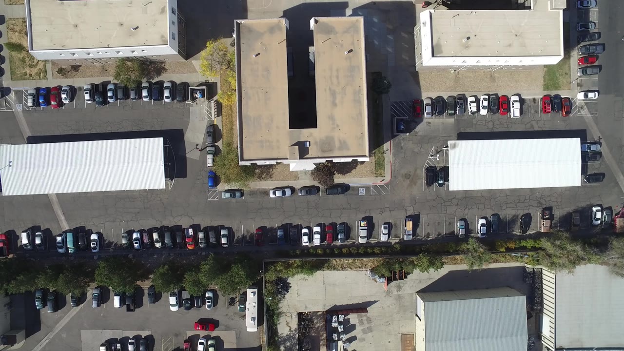 Top-down parking lot with buildings and cars