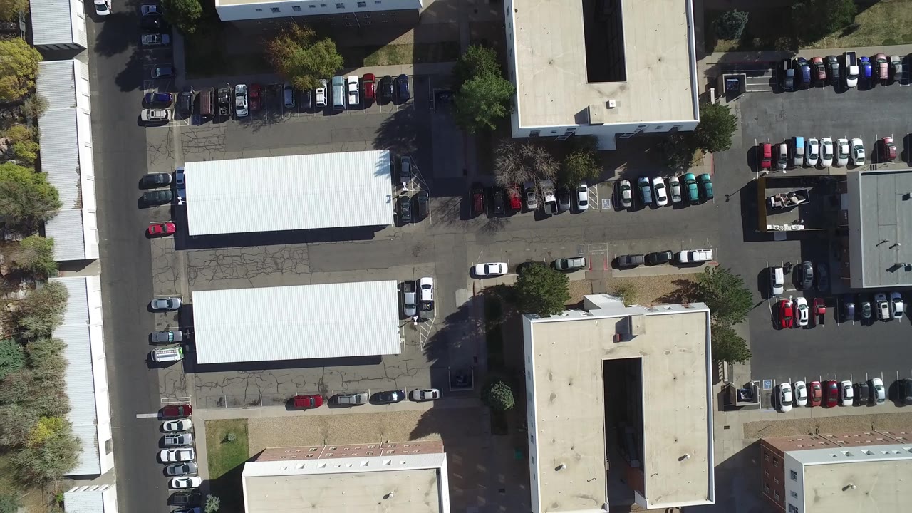 A slightly shifted overhead view in Hidden Lake, Colorado shows white roofs, rows of cars, paved drives, trees, and no visible people.