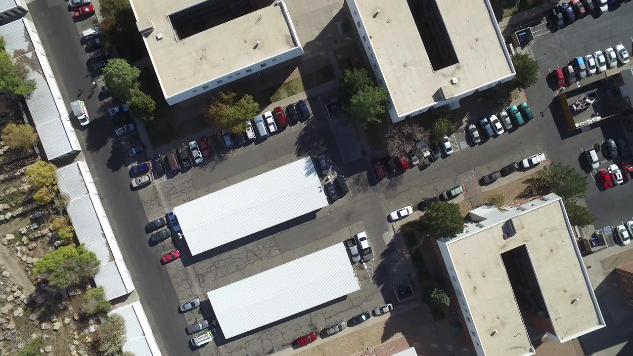 At 0:01, the Hidden Lake overhead view holds on pale flat roofs, shaded parking edges, clustered cars, and dry landscaping, with no visible people.