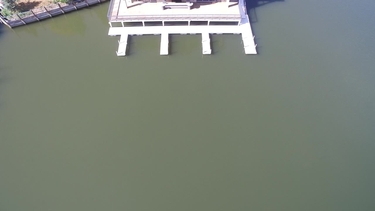 White pier cropped at top over still lake water