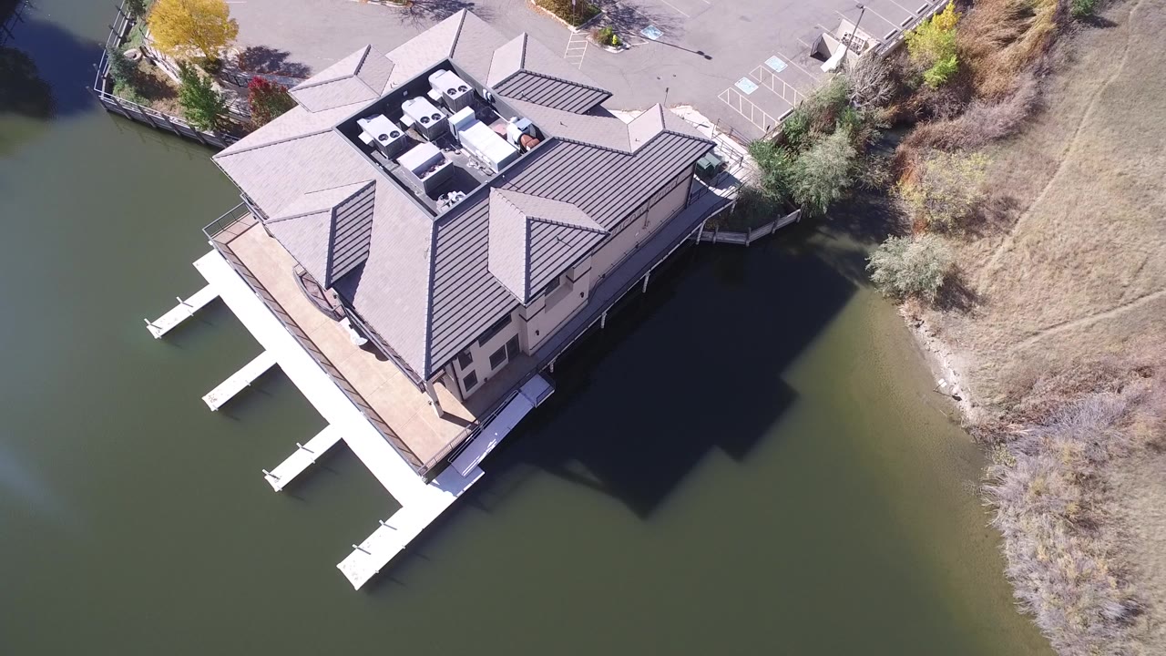 Overhead view of a lakeside house with white dock slips.