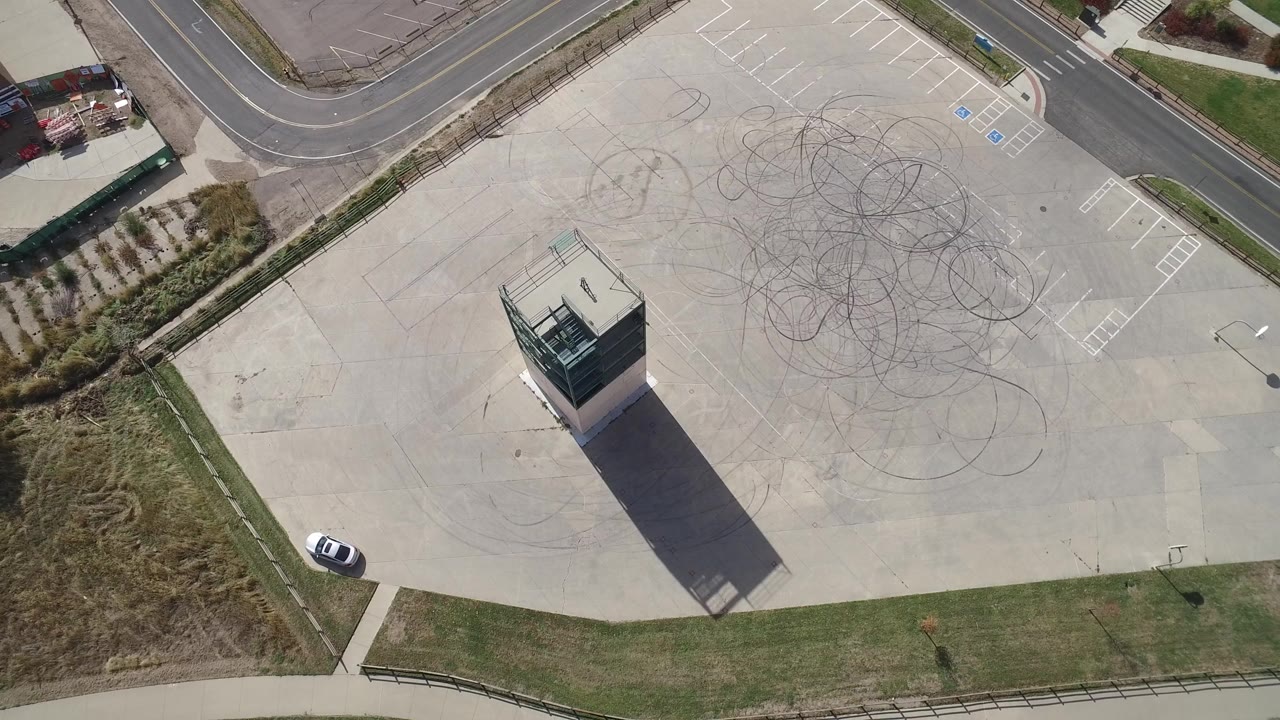 Overhead view of a concrete slab with a tall narrow structure and tire marks