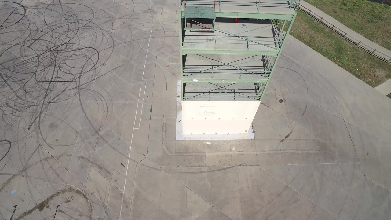 Top-down view of a tower beside tire-marked pavement.