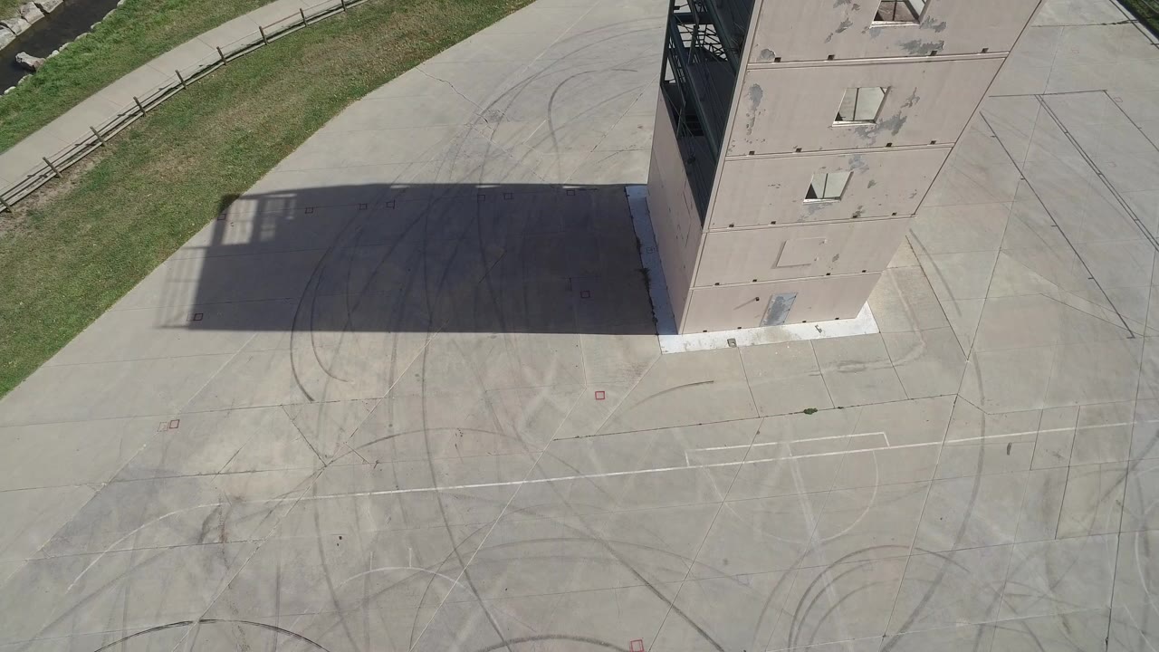 Overhead view of a concrete structure beside an empty paved area.