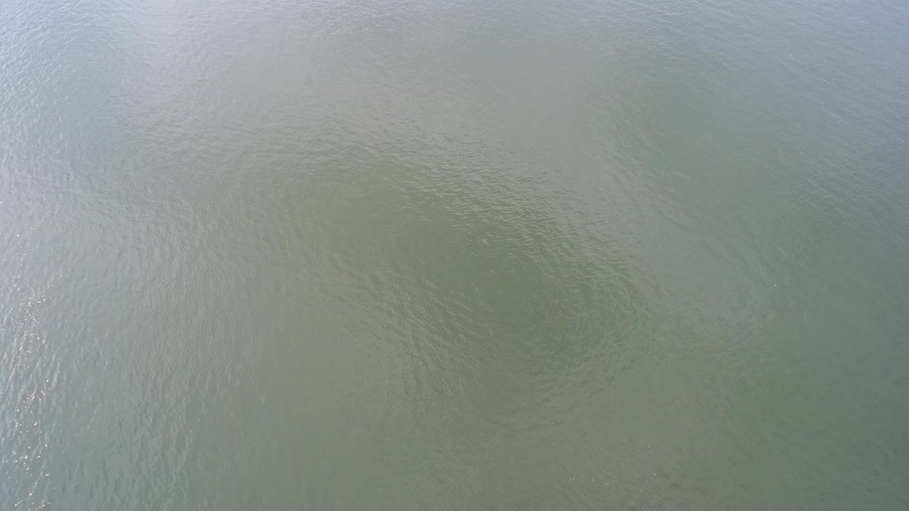 Pale green lake water with small ripples