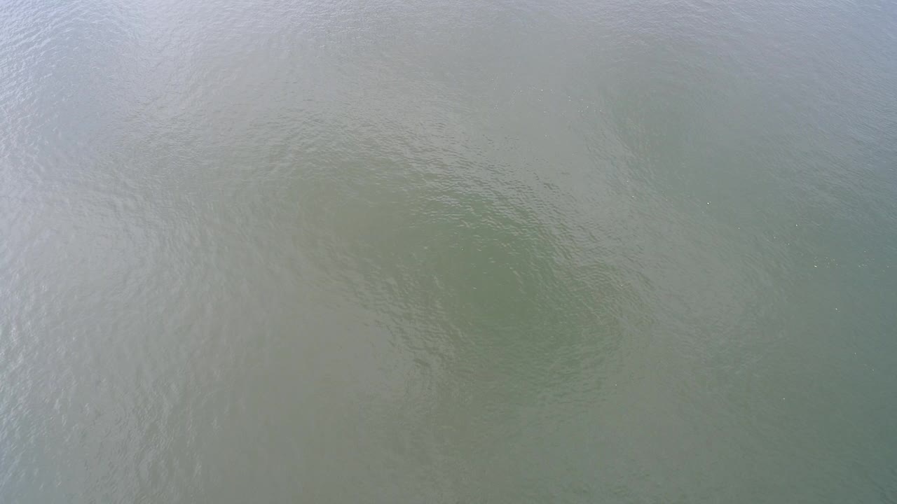 Green-gray water surface at Hidden Lake, Colorado, with faint ripples, pale reflection, and no visible people.