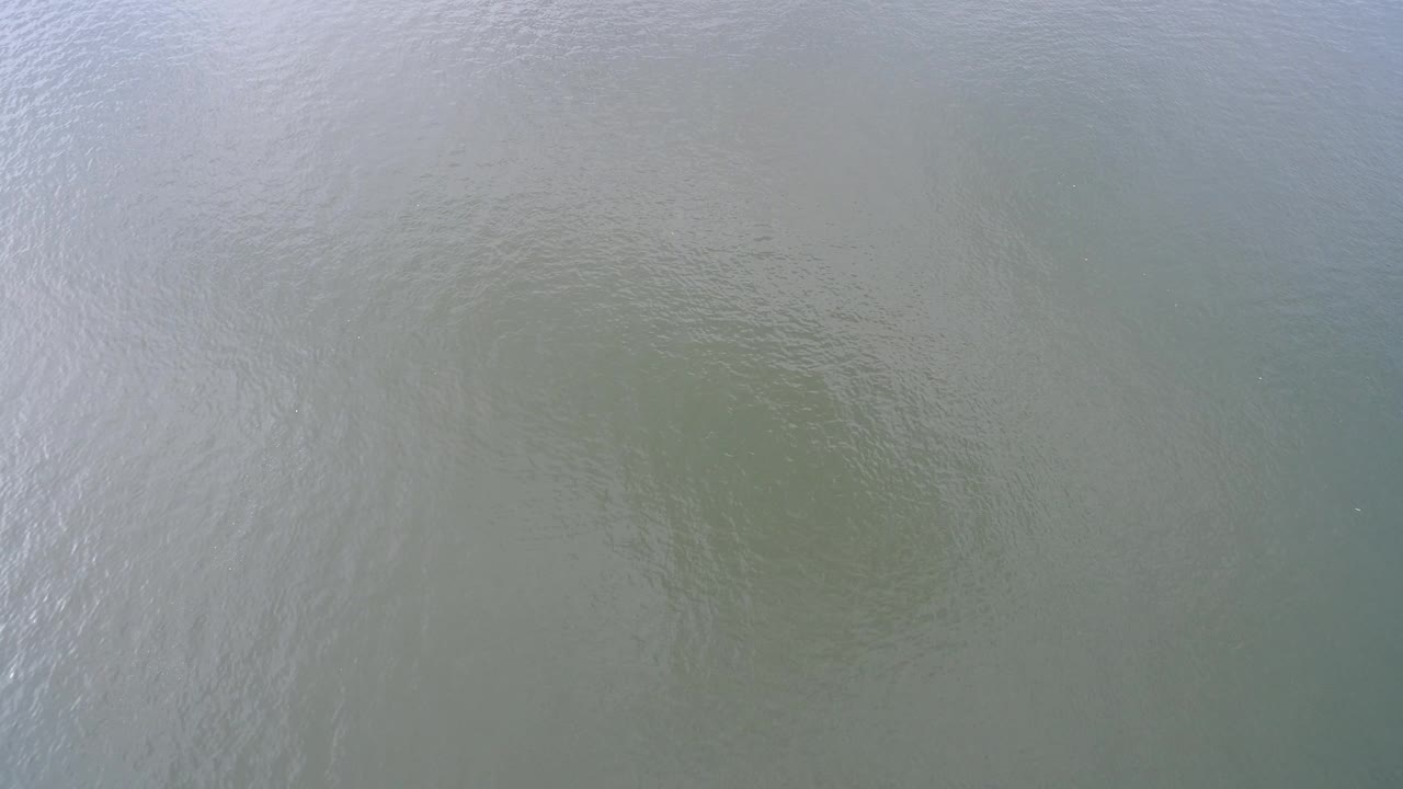Blue-green Hidden Lake surface shows a brighter band of reflected ripple texture along the left side, with no visible people.