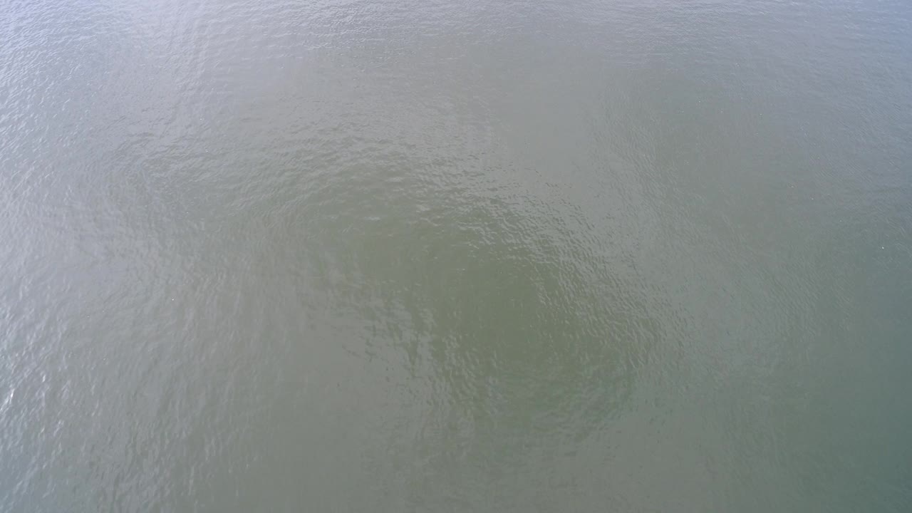 Hidden Lake, Colorado water surface with fine ripples, muted reflection, and a faint darker area under the water, no visible people.