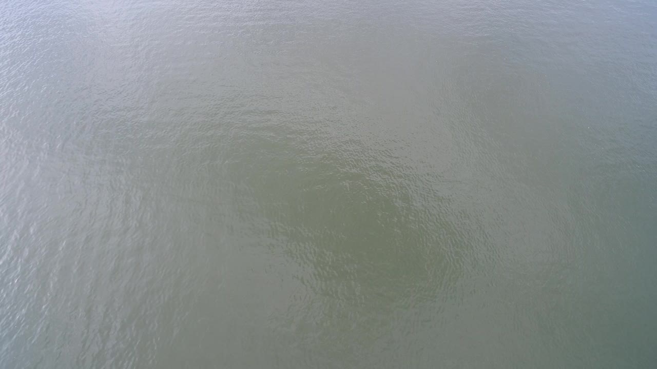 High-angle view of green-gray Hidden Lake water with broad soft ripples and no visible people.