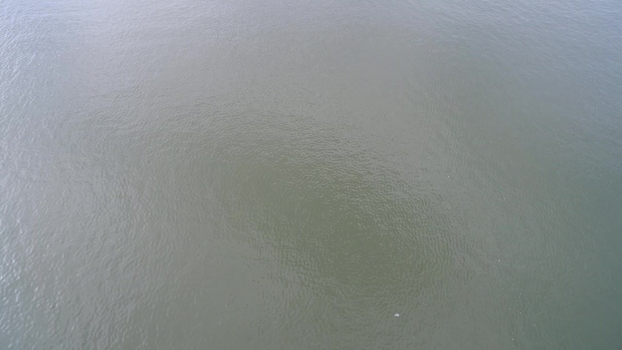 Top-down view of pale blue green water over shallow sand at Hidden Lake, Colorado, with fine ripples and no visible people.