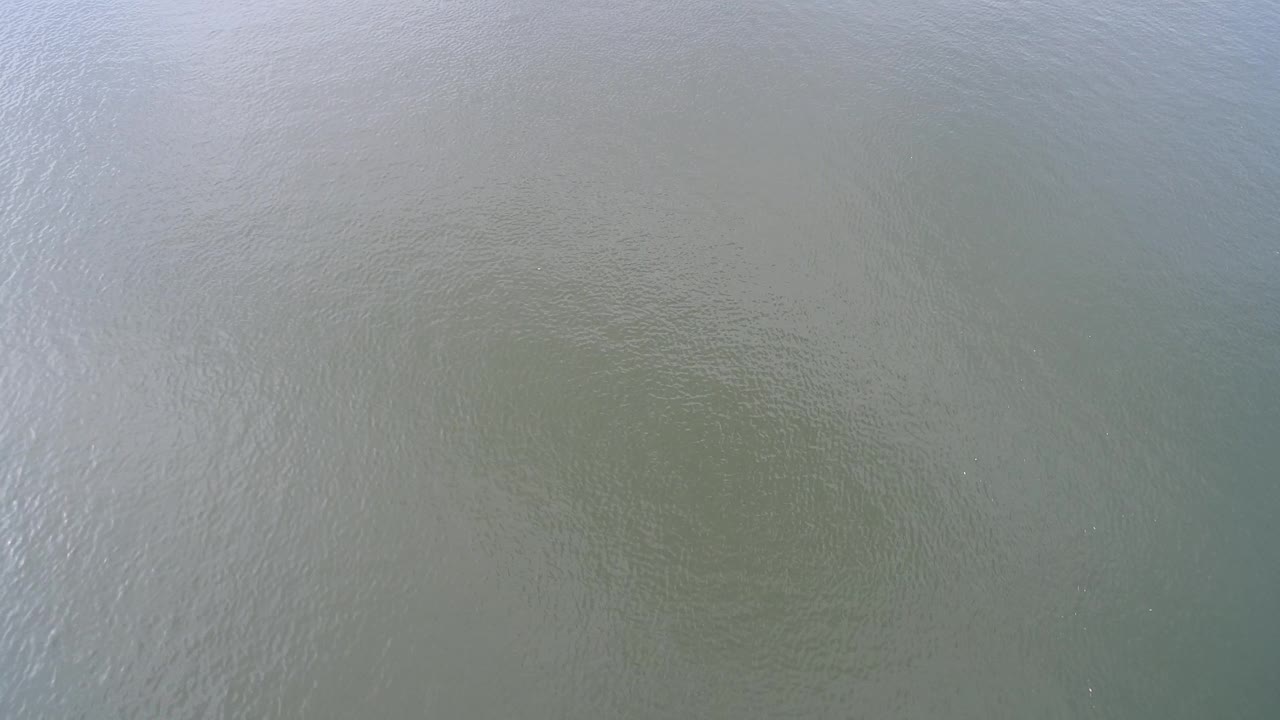Blue green lake surface with subtle sand pattern