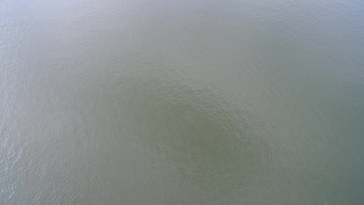 Pale blue-green water at Hidden Lake, Colorado fills the first frame with fine ripples, soft reflection, and no visible people.