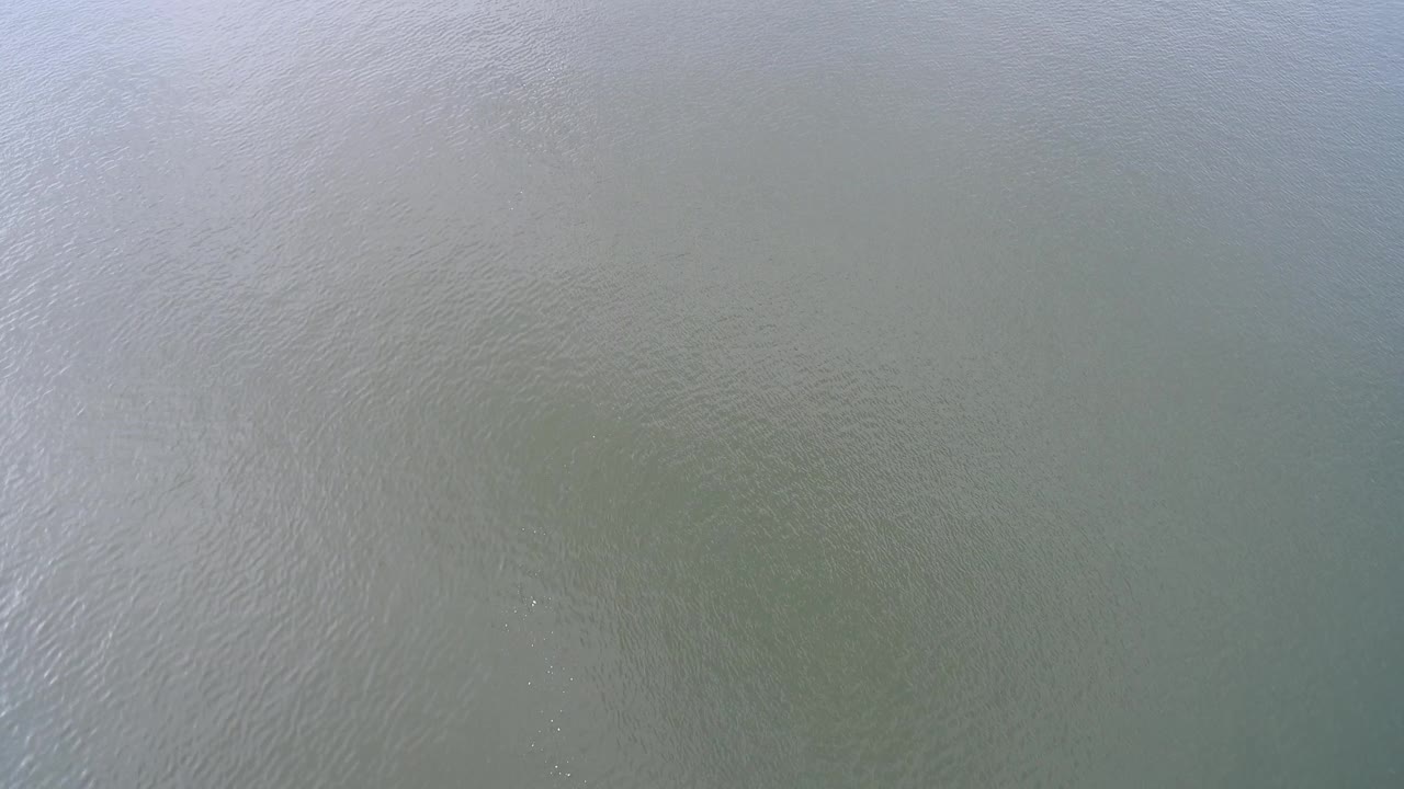 Murky water surface with fine wave patterns.