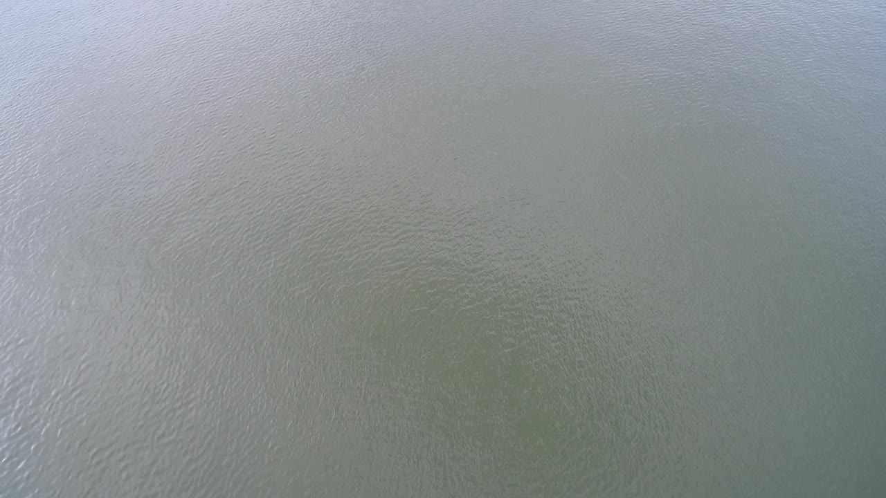 Top-down lake water with a brighter reflective streak