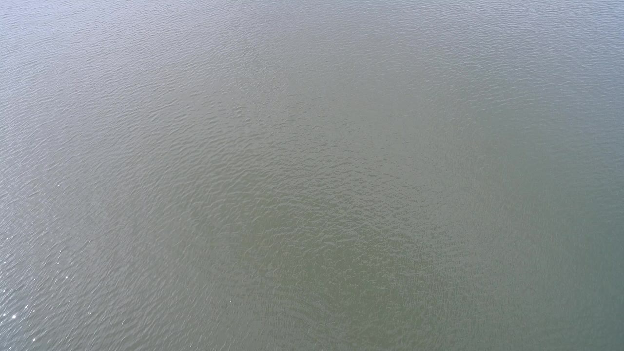 Rippling lake water with pale reflection across the surface.