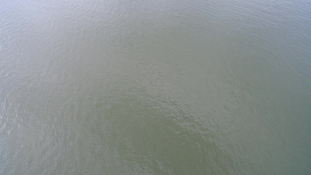 Top-down view of rippled green-gray water