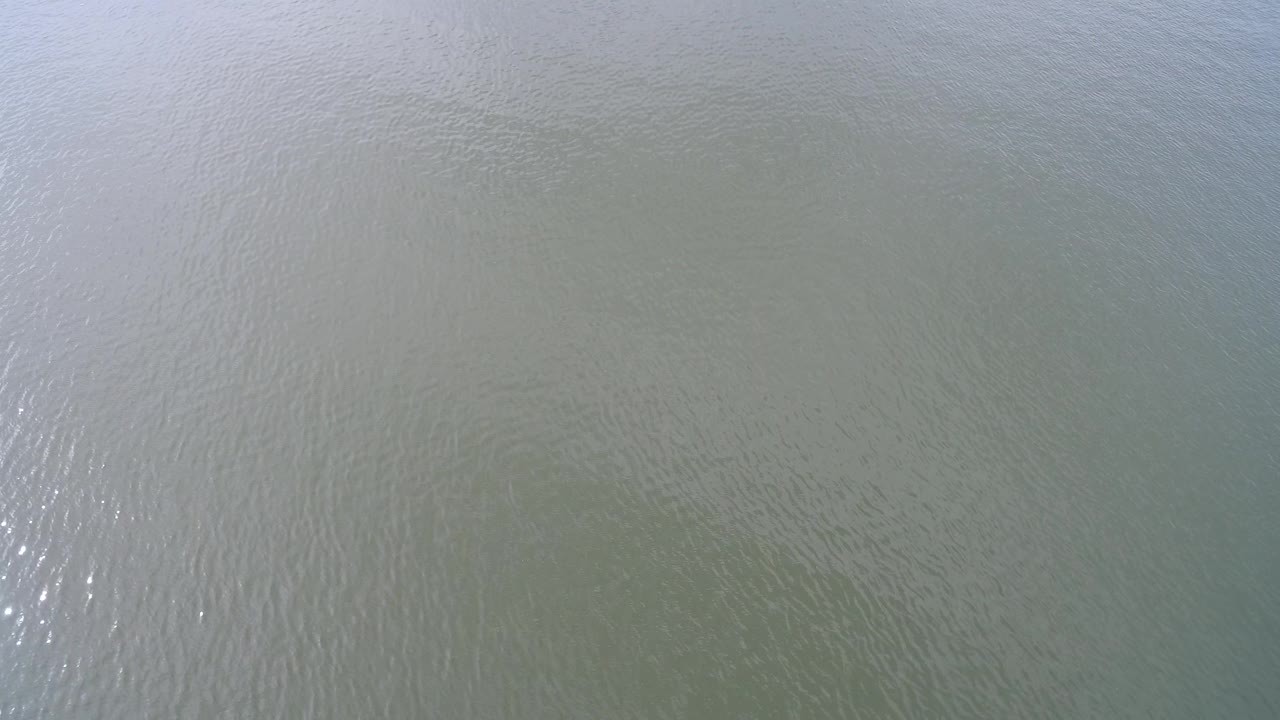 Muted lake water seen from directly above with fine ripples.