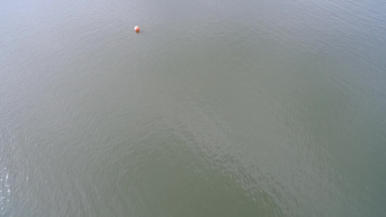 Small orange ball near the upper right over lake water.