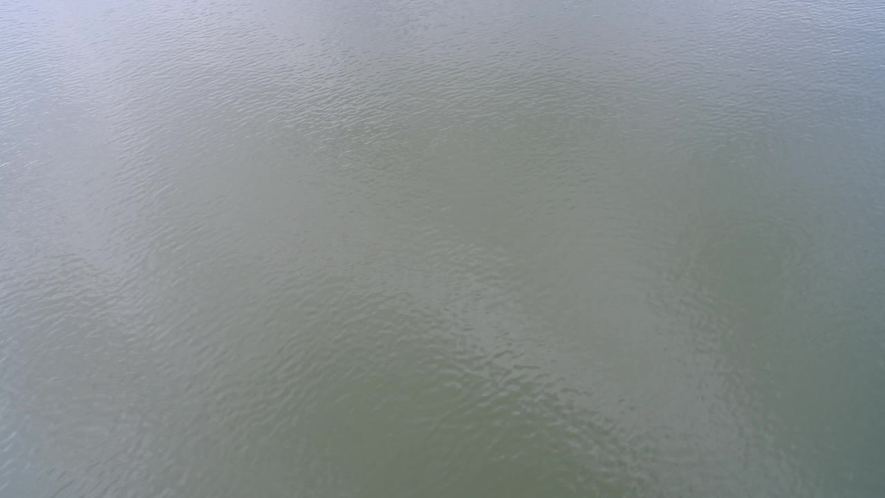 Muted water surface at Hidden Lake, Colorado, with soft blue reflection across the upper area and no visible people.
