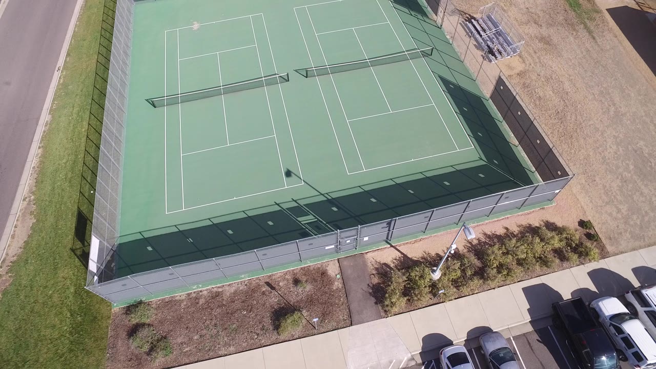 At 0:01, the Hidden Lake, Colorado frame keeps the fenced courts centered with parked cars along the lower edge and no visible people.