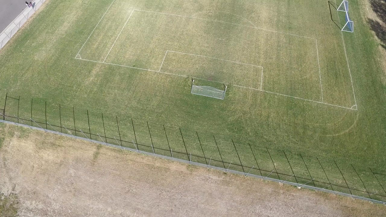 Overhead view of a marked soccer field at Hidden Lake, Colorado, with a small goal near the lower center, a fence at the bottom, and tiny people at the far upper-left edge.