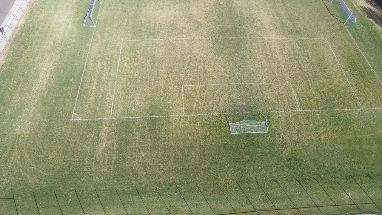 Overhead view of a green soccer field in Hidden Lake, Colorado, with pale field markings, a small goal near the lower center, and no visible people in this frame.