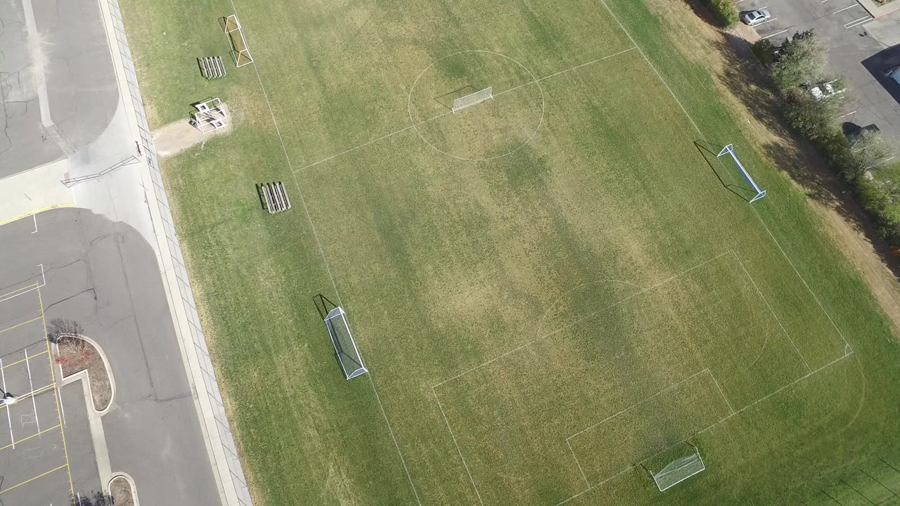 Aerial frame over the Hidden Lake football field showing the central turf, pale field markings, goal posts near the edges, and no visible people.