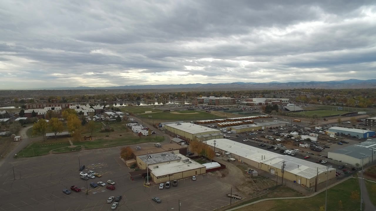 Hidden Lake, Colorado aerial view with a broad paved lot in the foreground, warehouses and roads in the midground, distant housing, and no visible people.