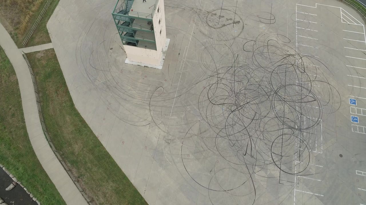 Overhead parking area with tire marks and a tall small building.