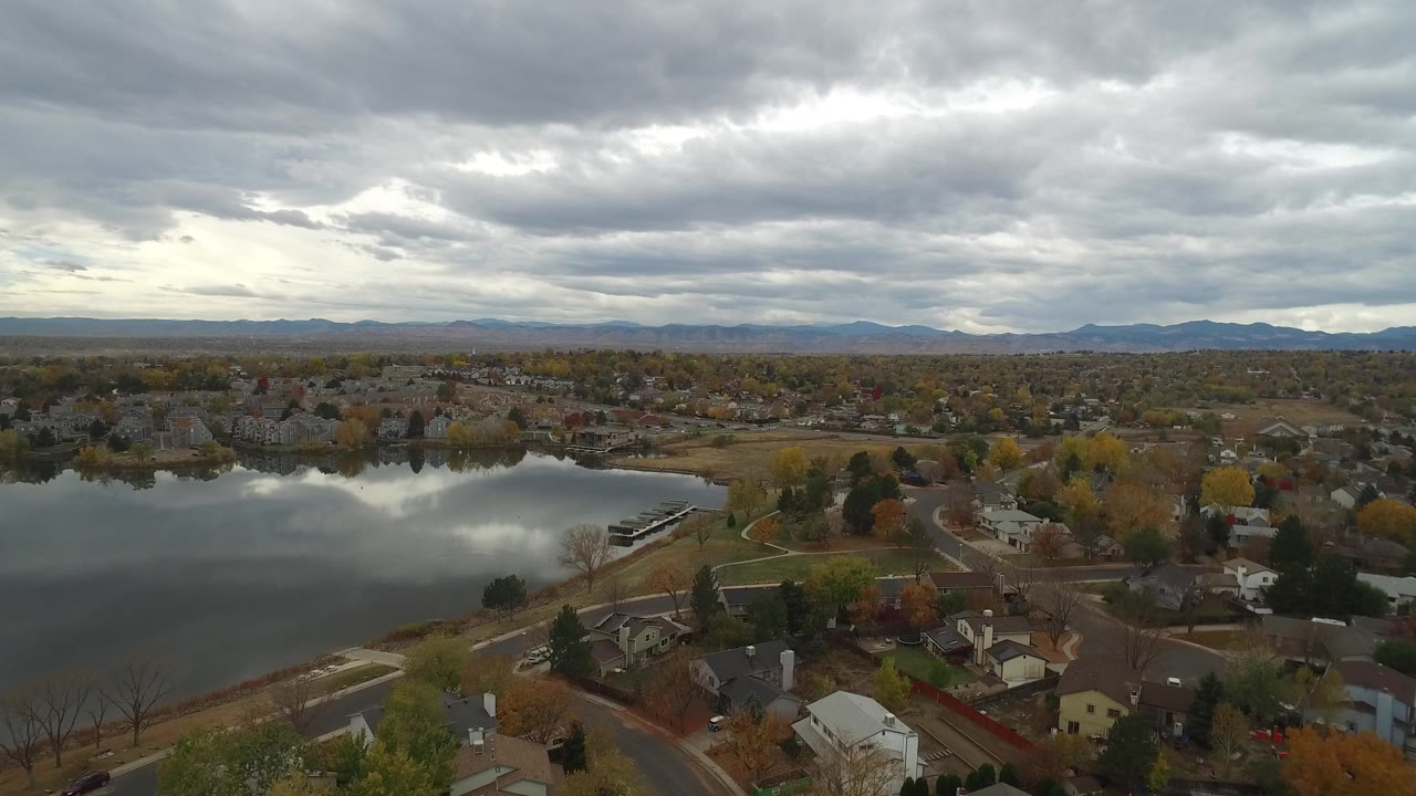 Wide aerial over a residential lakeside area with heavy cloud cover.