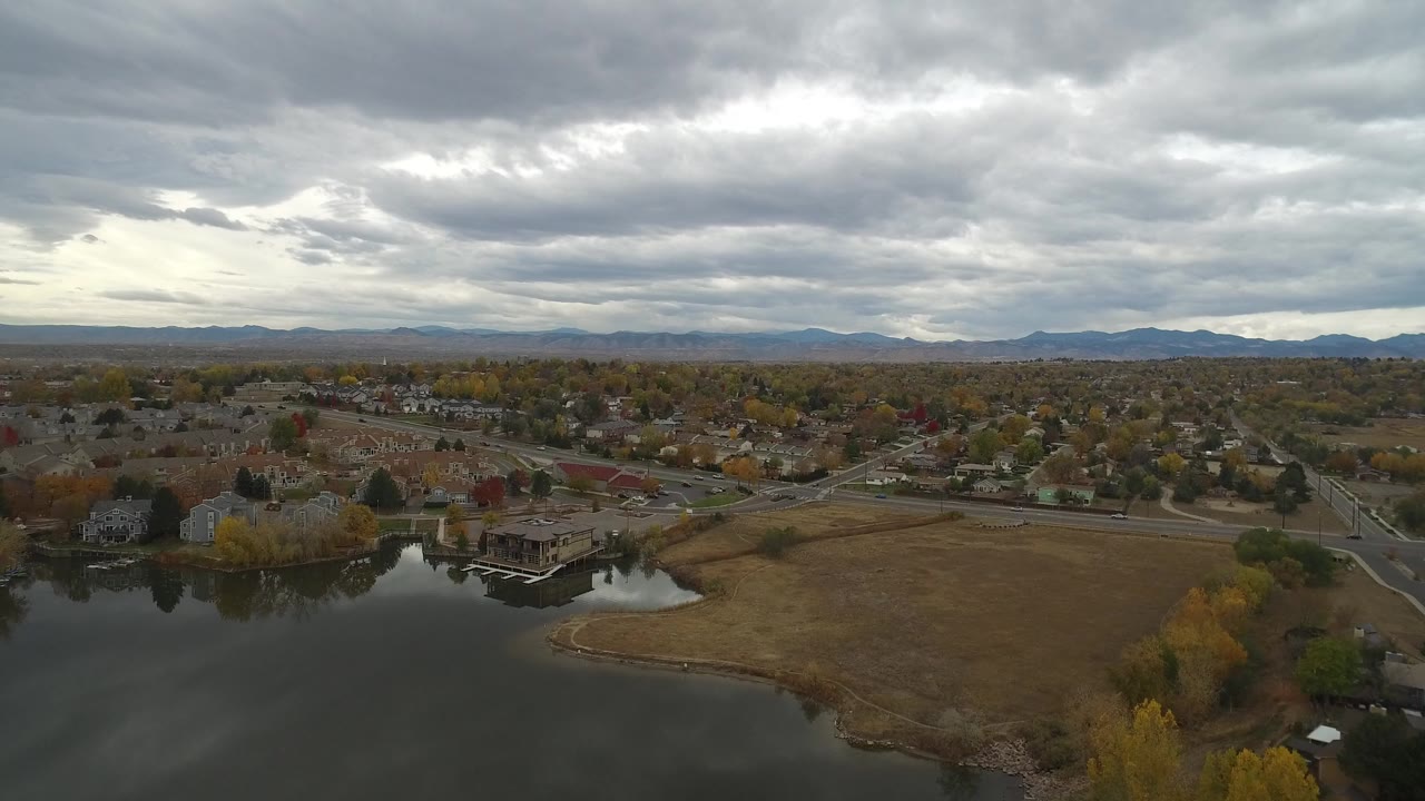 Aerial view over a lake, residential streets, and cloudy sky