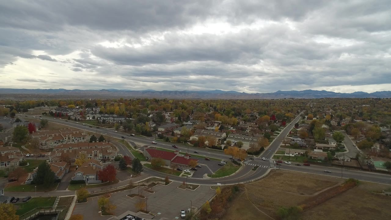 Aerial view of a suburban road junction beneath heavy clouds.