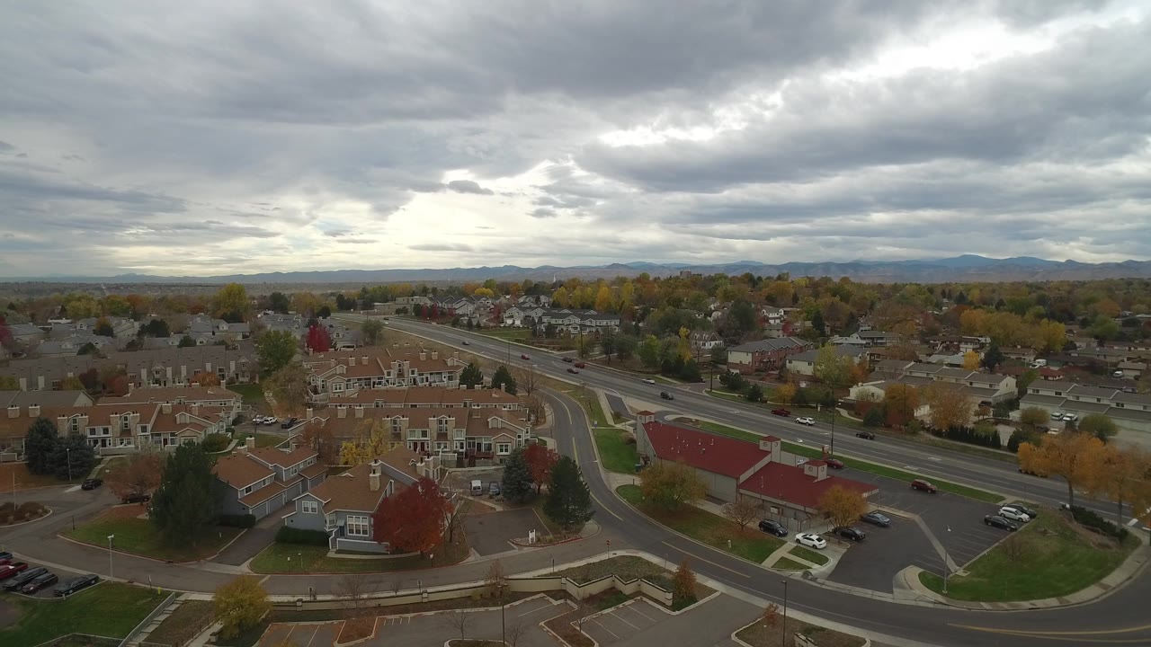 High view of a neighborhood road junction beneath layered gray clouds