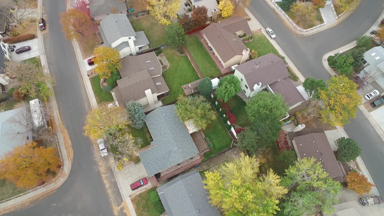 Second frame shows the Hidden Lake residential block from above, with a gray-roofed house near the lower left, brown rooftops, driveways, and no visible people.