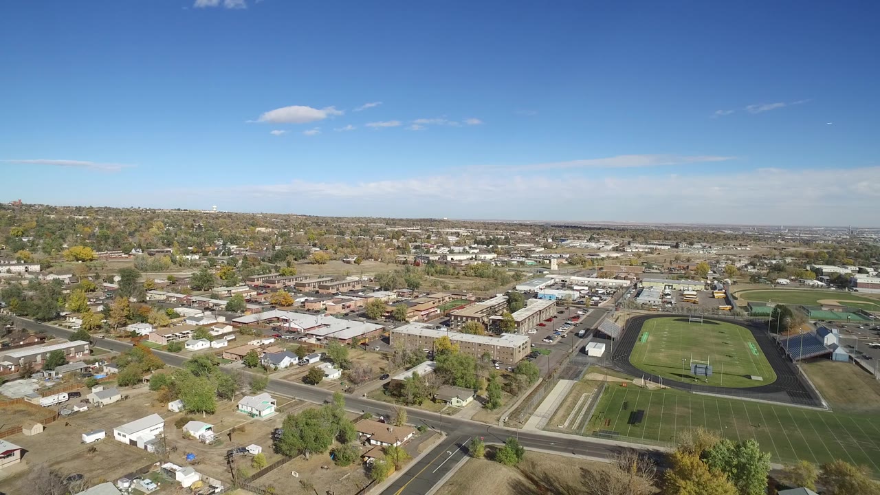 Aerial frame in Hidden Lake, Colorado, with the running track and playing fields slightly right of center, homes in the foreground, and no visible people.